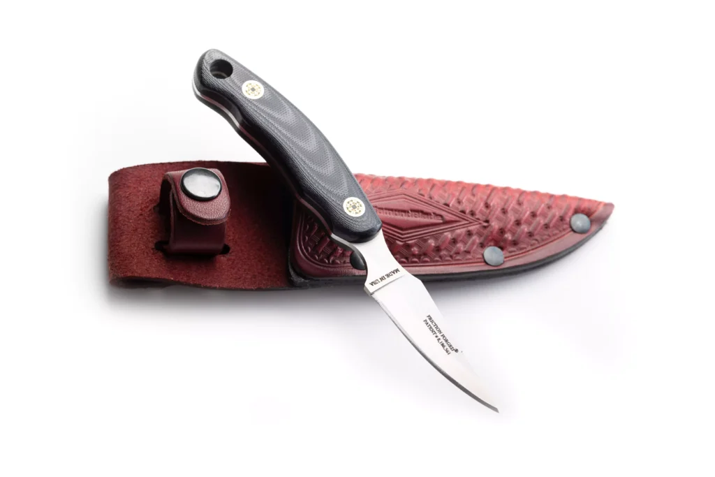Pinnacle II fixed blade knife with black G10 handle resting on its leather sheath by DiamondBlade Knives