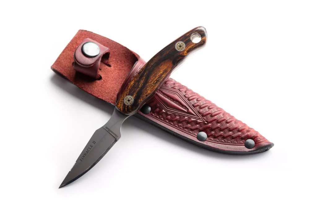 Pinnacle II knife with ironwood handle resting on DiamondBlade leather sheath