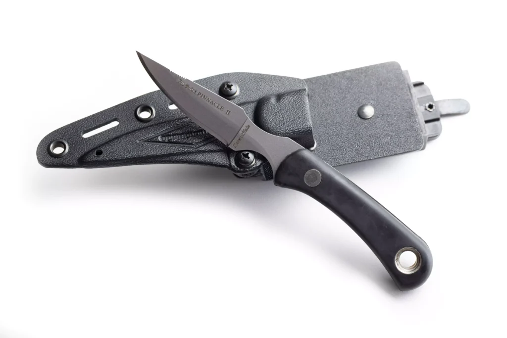 Pinnacle II fixed blade knife with black handle resting on DiamondBlade Kydex sheath