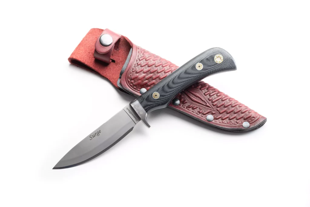 DiamondBlade Surge knife with G10 OD black handle resting on red basketweave leather sheath