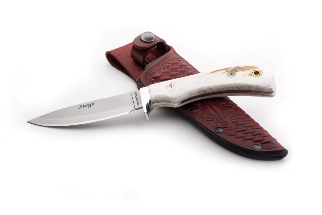 DiamondBlade Surge knife with stag handle resting on red tooled leather sheath