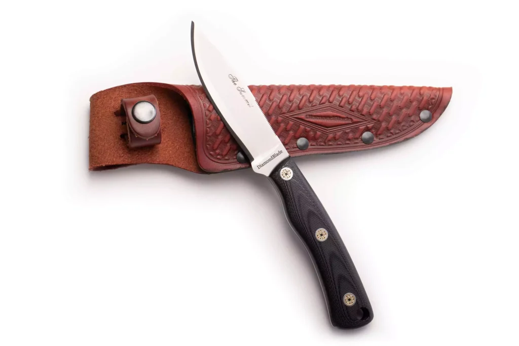 DiamondBlade Summit knife with black G10 handle and friction-forged blade resting on basketweave leather sheath